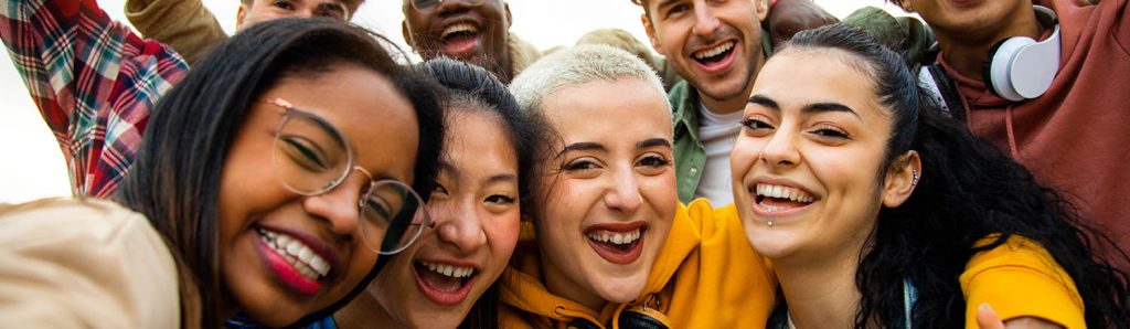 Group of multiracial teen college friends having fun outdoors.