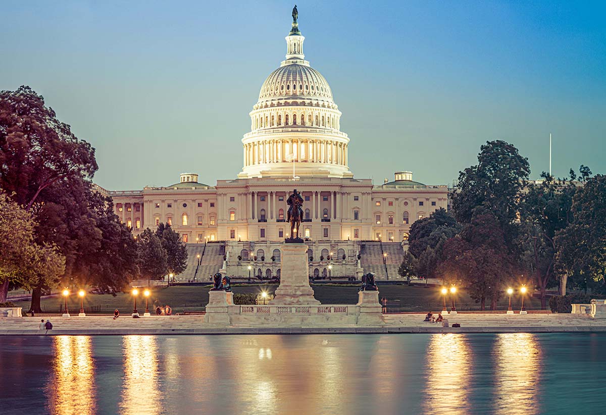 Panorama of the Capitol of the Unites States in evening light with the Capitol Reflecting Pool in the foreground.